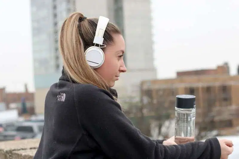 woman outside wearing white headphones